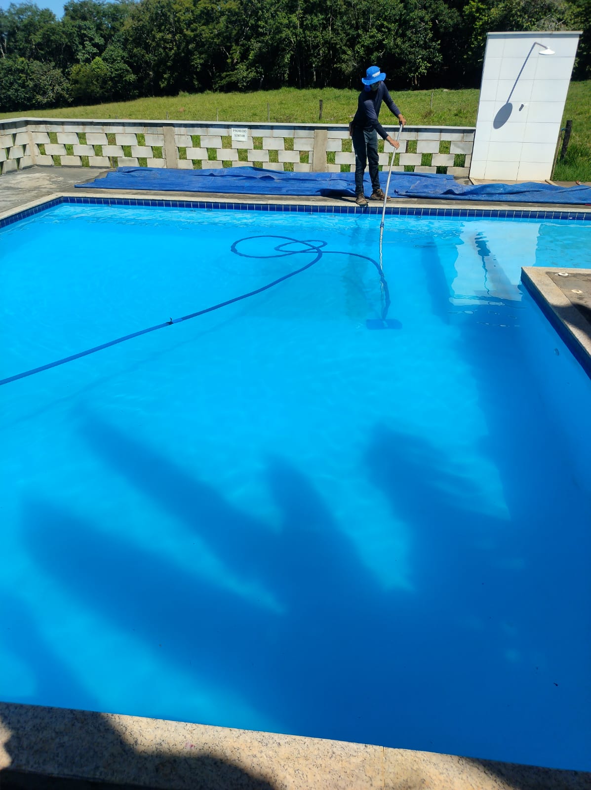 Profissional realizando limpeza de piscina